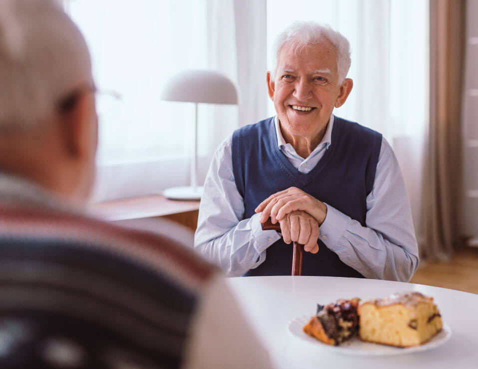 Senior man sharing a snack with a friend