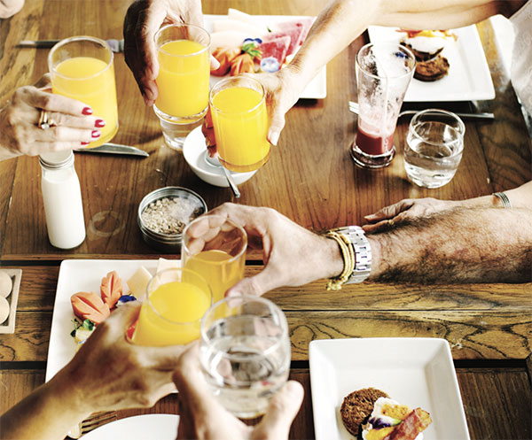 Seniors toasting with orange juice at breakfast