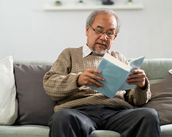 senior man reading on the couch