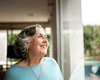 senior woman smiling and looking out a window