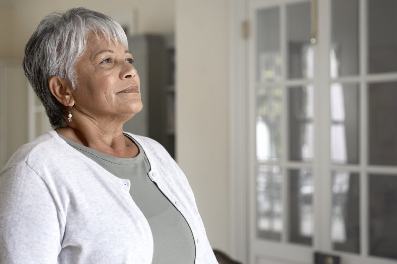 senior woman poised looking out a window