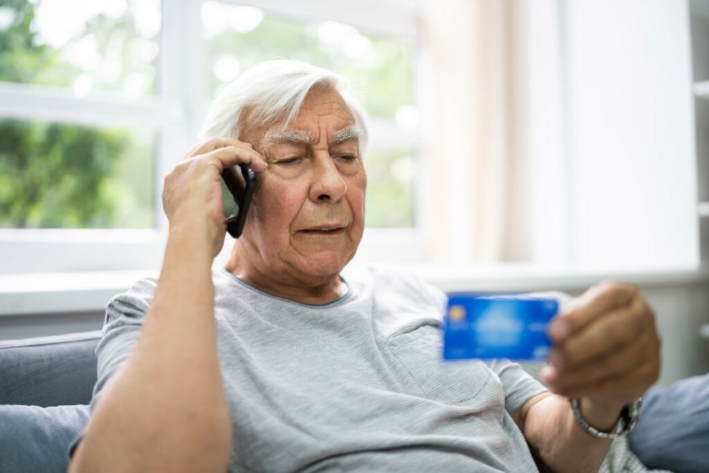 Senior man activating a credit card by phone