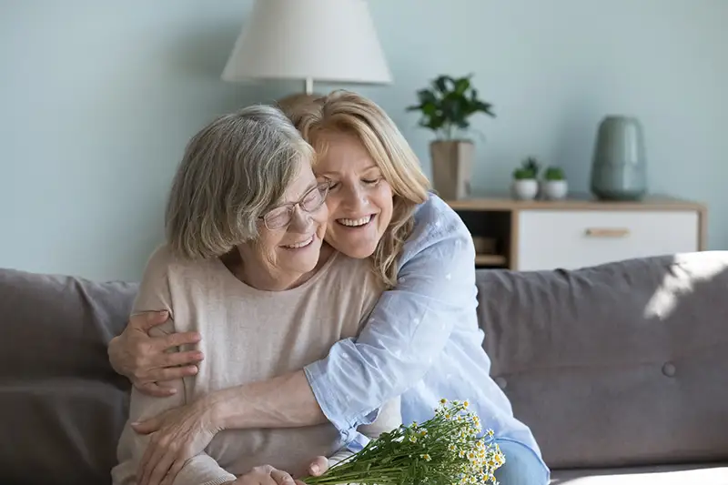 Adult woman hugging senior woman after discussing what is respite care ? and their options.